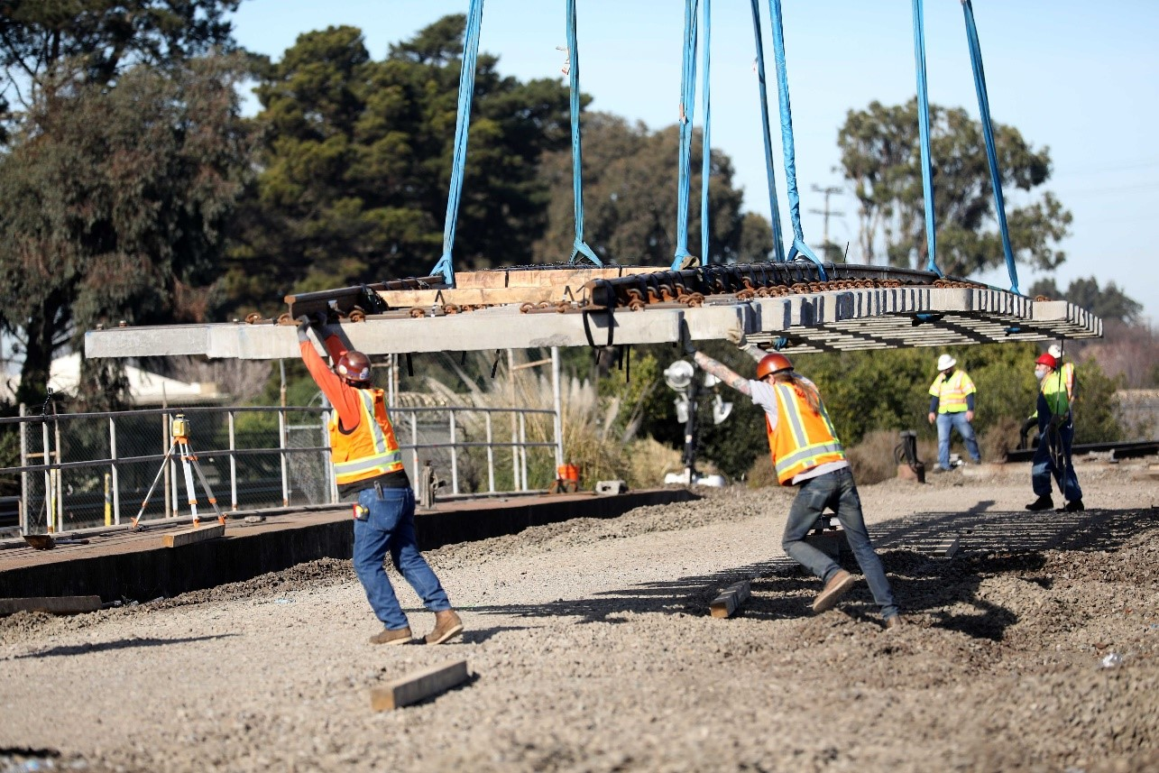 Track, tie and switch renewal in progress with a crane setting rail panels